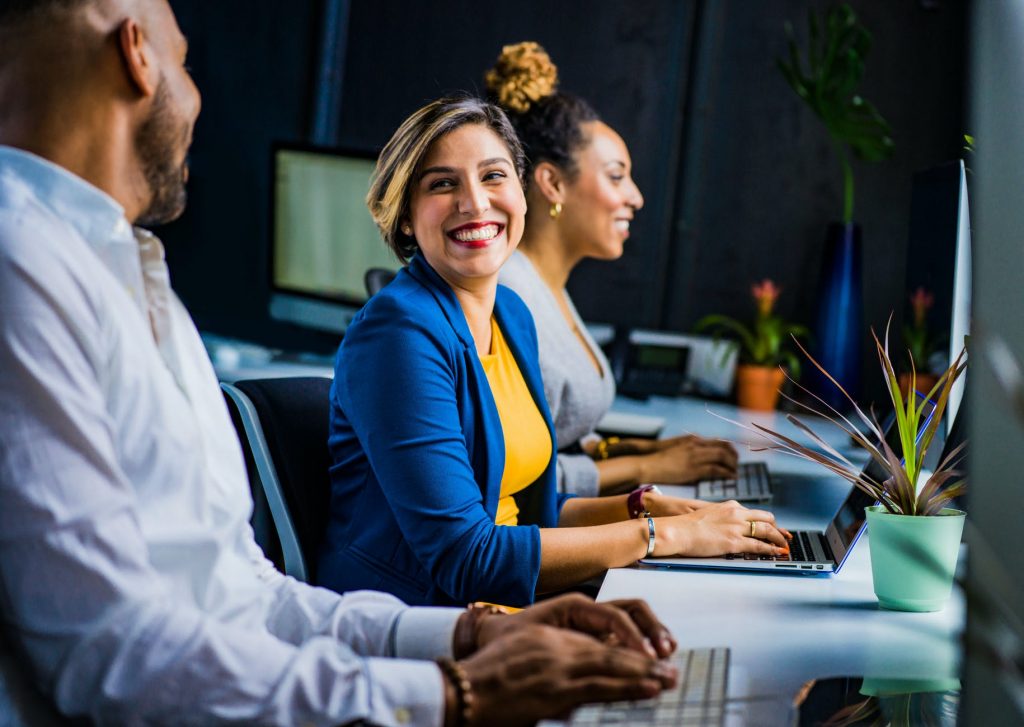 Pessoas no trabalho sorrindo. A Importância do Pessoal na Pequena Empresa; O que é Marketing Interno ou Endomarketing?