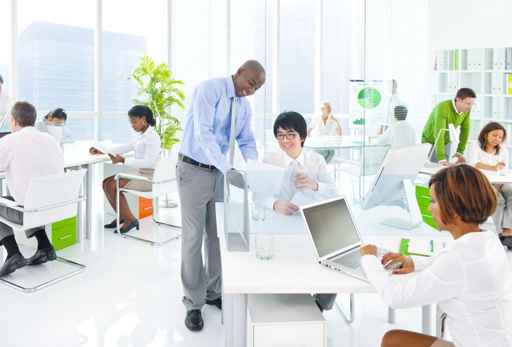 Foto de pessoas em um ambiente de trabalho físico e Social.