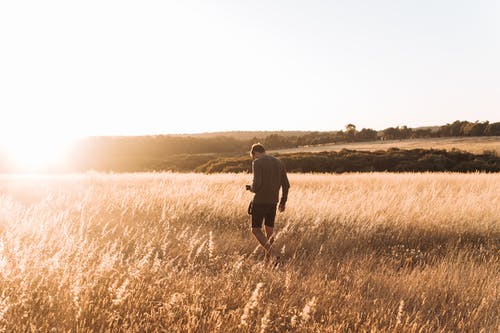 Um homem sozinho no meio de uma plantação baixa. O Homem e a Natureza; uma Dádiva? Um Acaso? E o Ocaso?