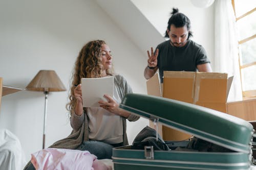 Um casal arrumando as malas para uma vigem. Viagem é investimento