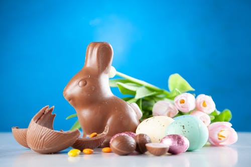 Coelho de chocolate cercado por ovos de páscoa. Feliz Semana Santa! Feliz Páscoa! Mas o que é a Páscoa?