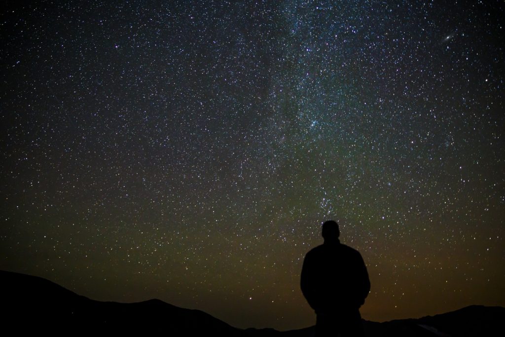 Silhueta de uma pessoa observando o céu estrelado. Filosofia e Cosmologia: A Physis e o Thauma Sempre Presentes