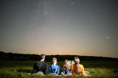 Pessoas esticas em um gramado olhando o céu. Considerações Finais do texto “Filosofia e Cosmologia: A Physis e o Thauma Sempre Presentes”