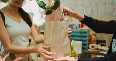 Atendente entregando uma bolsa com flores. Treinamento, Palestra ou Workshop – “Venda Mais com Qualidade: Foco no Atendimento ao Cliente”