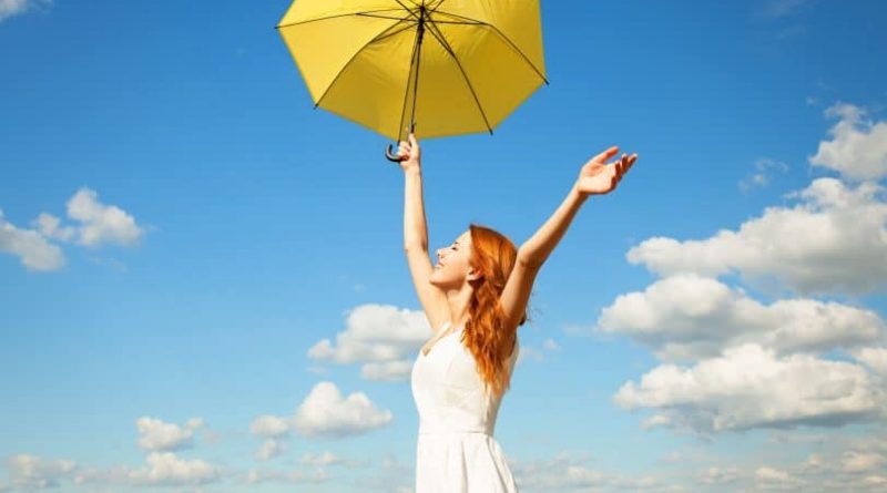 Uma Mulher com uma sombrinha amarela em um lindo céu azul. Viva o Agora. Agora!