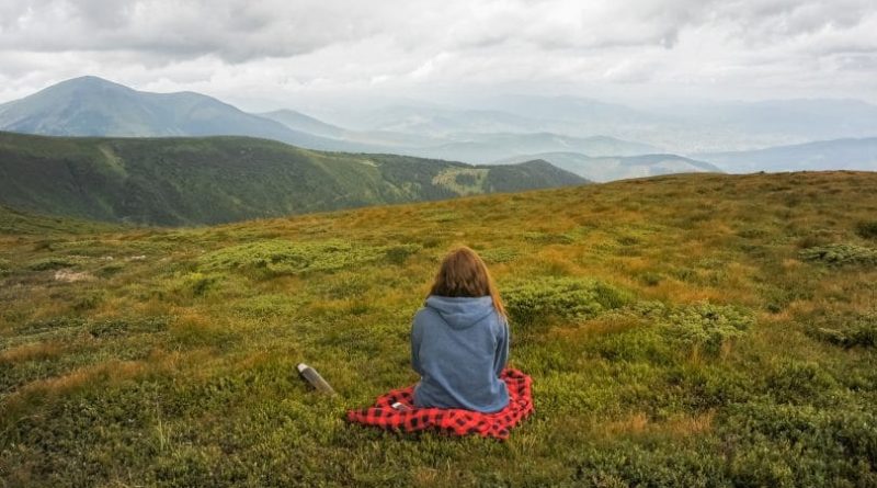Uma pessoa sentada tranquilamente observando a natureza. É preciso viver com mais calma.