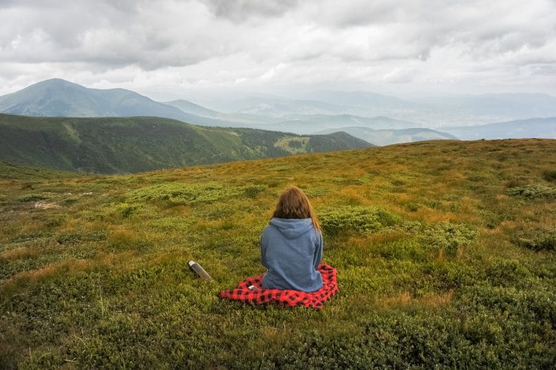 Uma pessoa sentada tranquilamente observando a natureza. É preciso viver com mais calma.