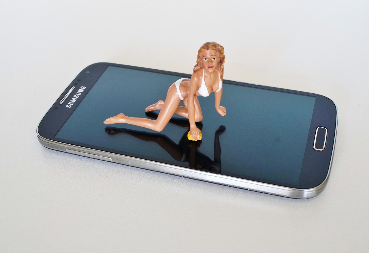 uma boneca acima de um Celular, Ser x Aparecer